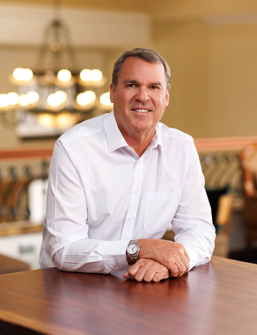 A man is sitting at a table with his hands on it. AI generated content