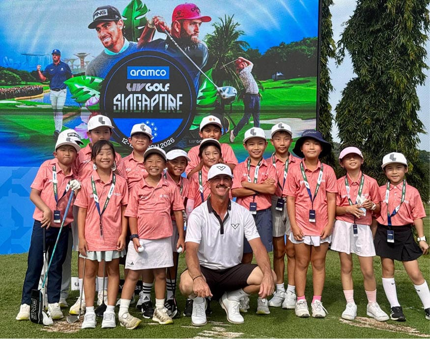 A group of children and adults pose for a photo in front of a large screen. AI generated content