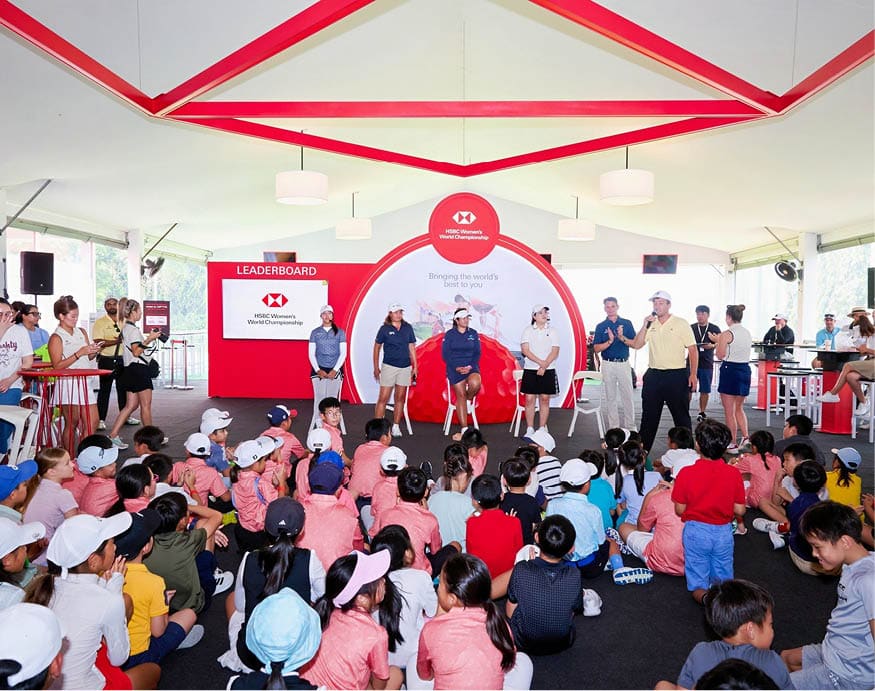 A group of people are sitting on the ground in front of a stage. AI generated content
