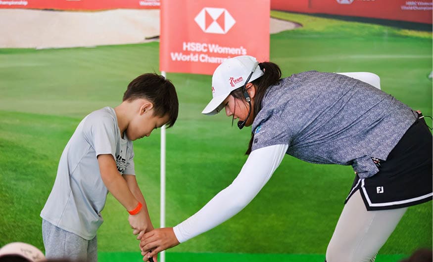 A woman is teaching a young boy how to swing a golf club. AI generated content