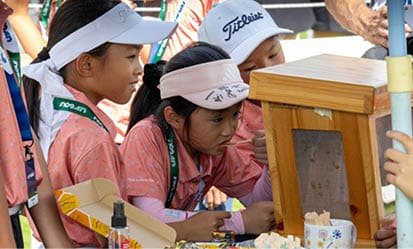 Three children are looking at a small wooden box. AI generated content