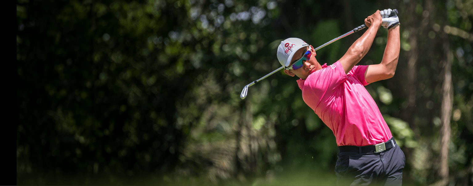 A man in a pink shirt is swinging a golf club at a ball. AI generated content