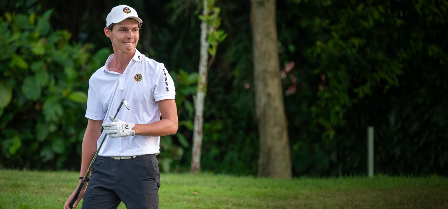 A man in a white shirt and black shorts is holding a golf club and walking on a grassy field. AI generated content