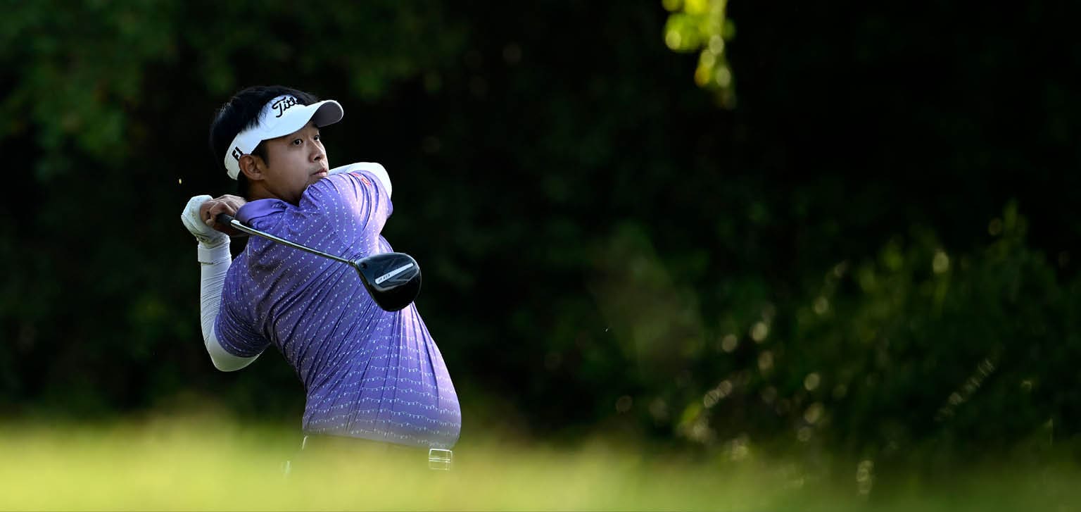 A man in a purple shirt is swinging a golf club on a golf course. AI generated content